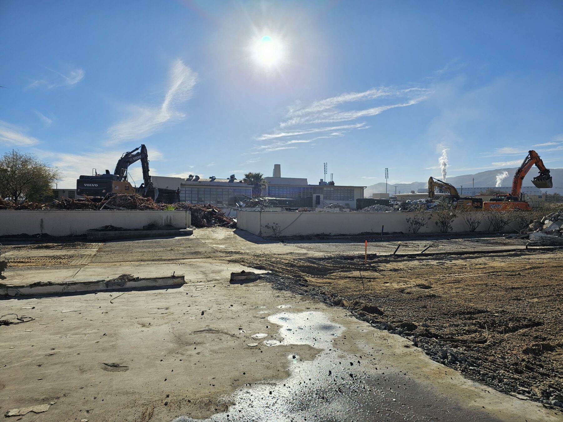 Photograph of old Trona High School campus during its 2025 demolition, construction machinery beside remnants of school buildings.