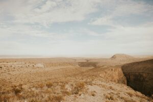 Illustrative desert landscape and building by Jorge Flores / Unsplash; not the Kelly Silver Mine or a photographed arsenic sampling site.