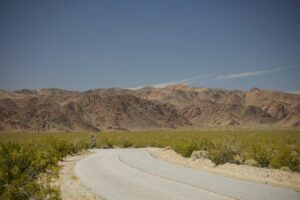 Illustrative remote desert road and mountains by Abhi Dasari / Unsplash; not an official BLM 2026 closure location or map.