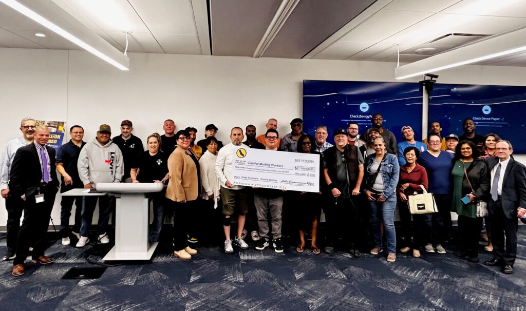 Group photograph of former Capital Mailing Services workers receiving payments at a Sacramento event on October 16, 2026. Photo: California Department of Industrial Relations.