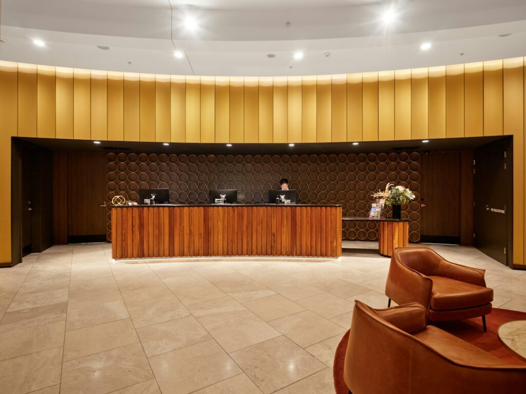 Illustrative image of a hotel reception desk by Neon Wang / Unsplash; not a specific California hotel or example of a fee violation.