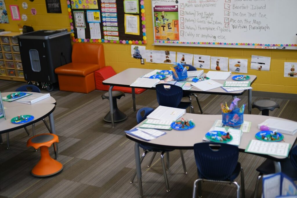 Illustrative photograph of a classroom with colorful tables, chairs and student materials; not a specific California school. Far Chinberdiev / Unsplash.