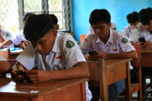 Illustrative students using phones in a classroom, not NMCUSD students or an image of a local policy violation