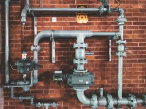 Illustrative photograph of industrial piping by Compagnons / Unsplash, not the Oroville Dam River Valve Outlet System.