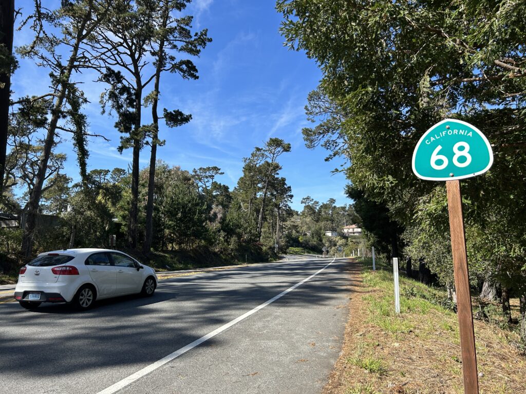 California Route 68 sign beside a scenic tree-lined stretch of Highway 68 photographed by Caltrans