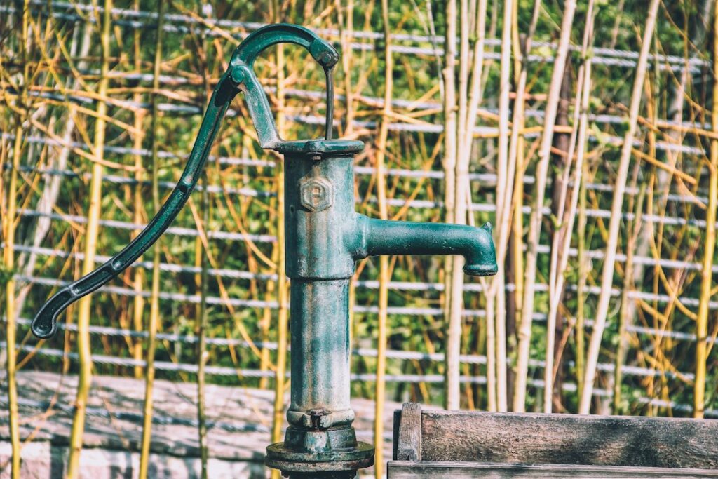 Illustrative old-fashioned manual water pump by Herbert Goetsch / Unsplash; not a modern Red Mountain permitted drinking-water well.
