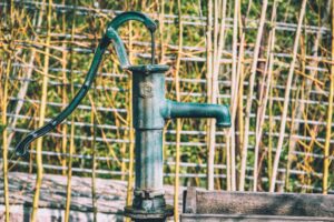 Illustrative old-fashioned manual water pump by Herbert Goetsch / Unsplash; not a modern Red Mountain permitted drinking-water well.