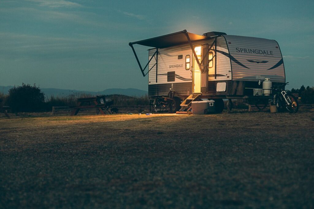Travel trailer in a campground on Vancouver Island, British Columbia, by Devon MacKay on Unsplash. Illustrative only; not a California permitted RV residence.
