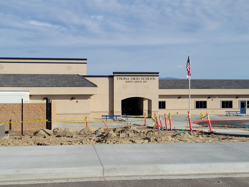 New Trona High School campus at 83655 Argus Avenue with blue trim, flagpole and new buildings; image from Trona Joint Unified School District facilities archive